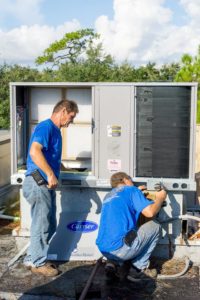 Two Coolco employees servicing an industrial AC unit