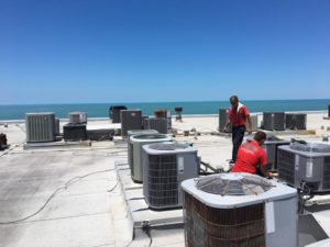 Coolco employees servicing a large number of AC units on rooftop